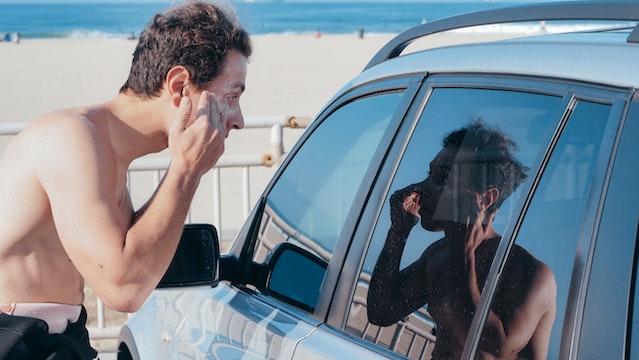 Man applying sunscreen to face